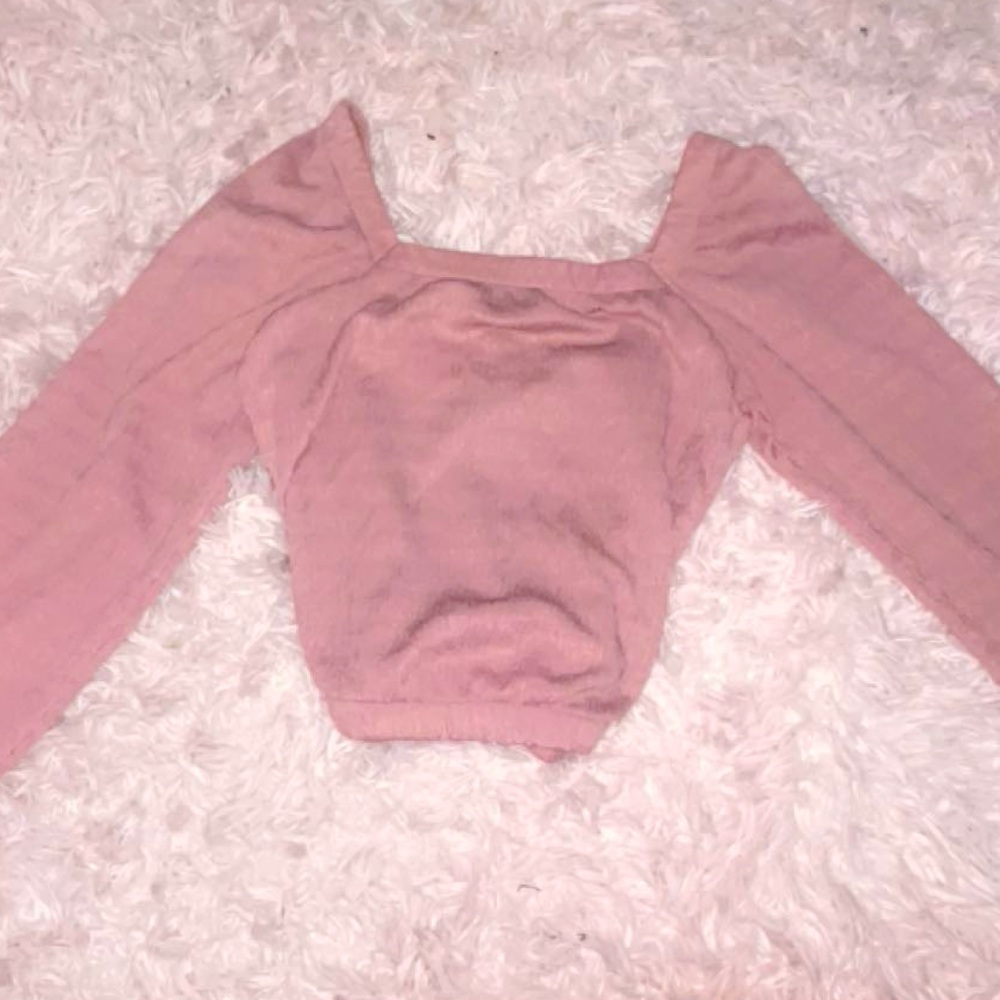 Thin pink long sleeve blouse, worn off and on the shoulders.